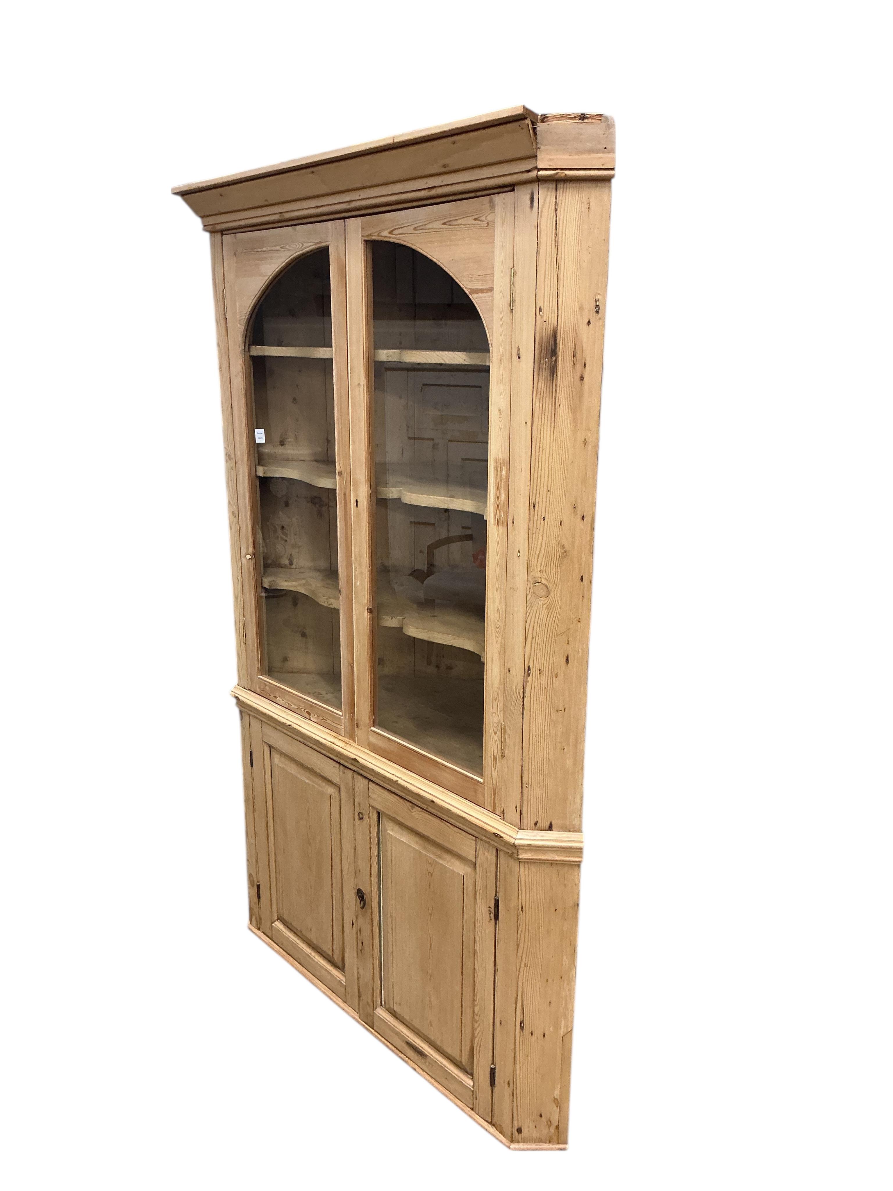 An early 19th century glazed pine standing corner cupboard, width 126cm, depth 62cm, height 191cm